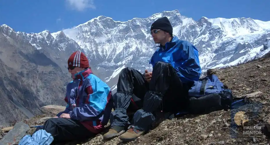 A couple is taking a rest after the hardest climb and enjoying the Himalayan panorama