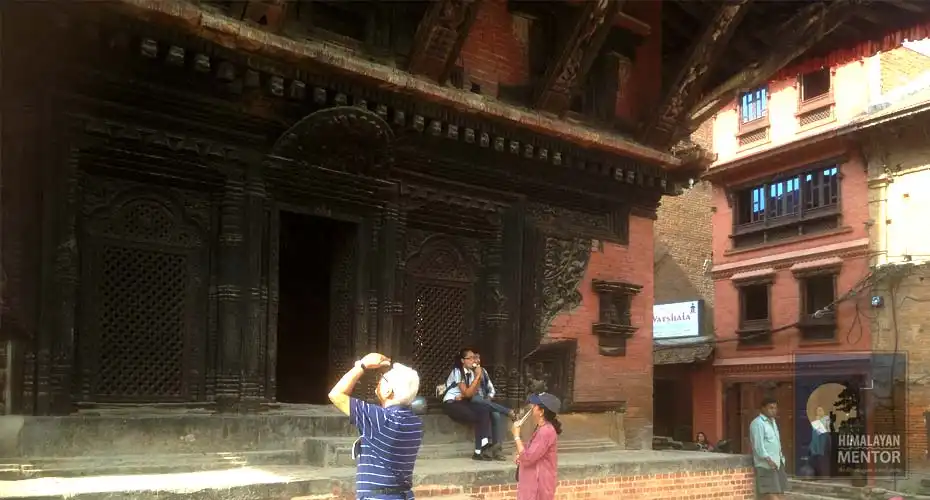 Our clients from the US are enjoying the beautiful wood carving windows and door at Patan Durbar Square. 