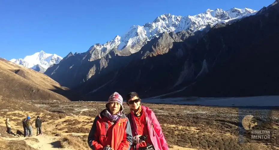 A couple is enjoying the Himalayan view at Kyangjin Gompa