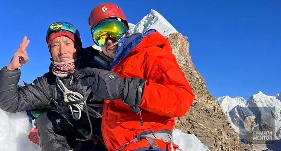 Our guide and client are posing for a photograph on the summit of Lobuche Peak